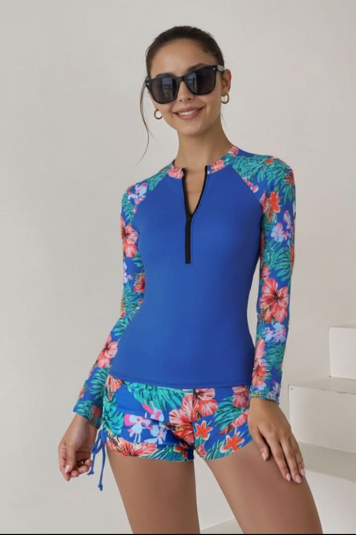 Elegant women's two-piece rashguard swimsuit, long sleeve top, high-waisted bottom, vibrant tropical print.