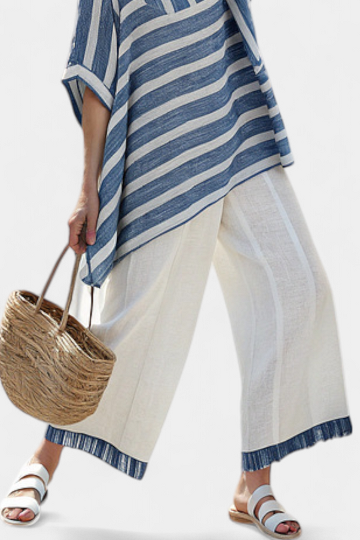 Fashionable women's striped outfit featuring a batwing top and wide-leg pants with a distinctive asymmetric hem.