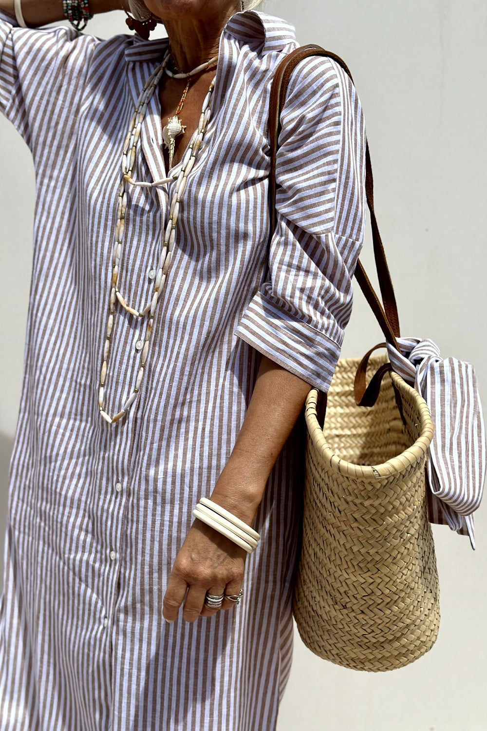 Soft fabric detail of an oversized striped women's midi dress with a button-down front and stylish collar.