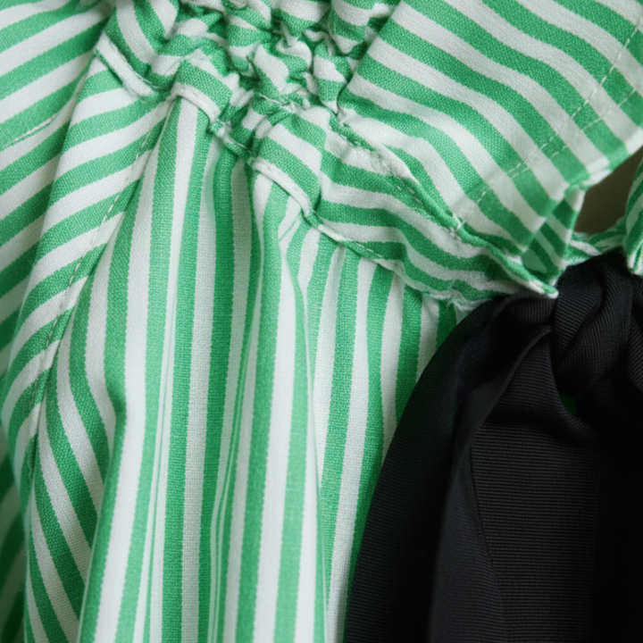 Relaxed fit women's striped blouse with a sophisticated bow tie and ruffles, suitable for office or fashion.
