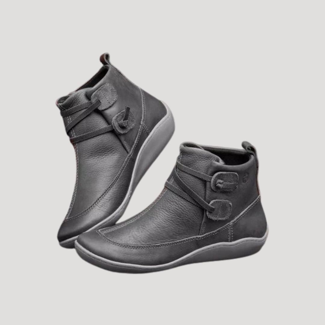 Close-up of women's black ankle strap boots, highlighting chic detailing for spring everyday wear.