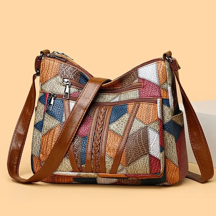 Close-up of the geometric patchwork design on a fashionable women's vegan leather shoulder bag.