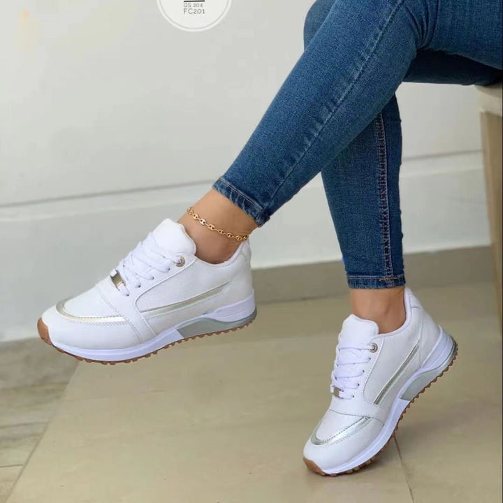 Modern women's platform sneakers, featuring chic gold trim and secure lace-up closure for versatile style.