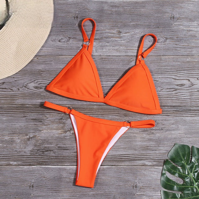 Folded women's sustainable two-piece bikini with adjustable straps, ready for summer travel.