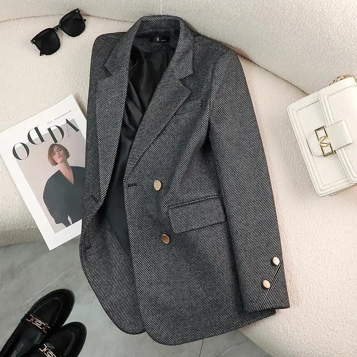 Stylish women's tailored jacket with prominent gold accents on the lapel, perfect for business casual attire