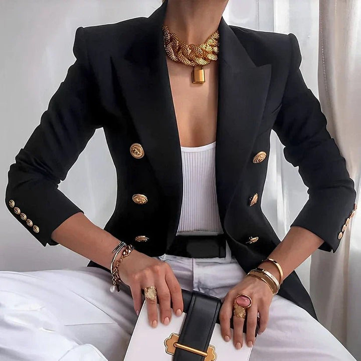 Women's tailored double-breasted blazer featuring elegant gold buttons. Professional office attire.