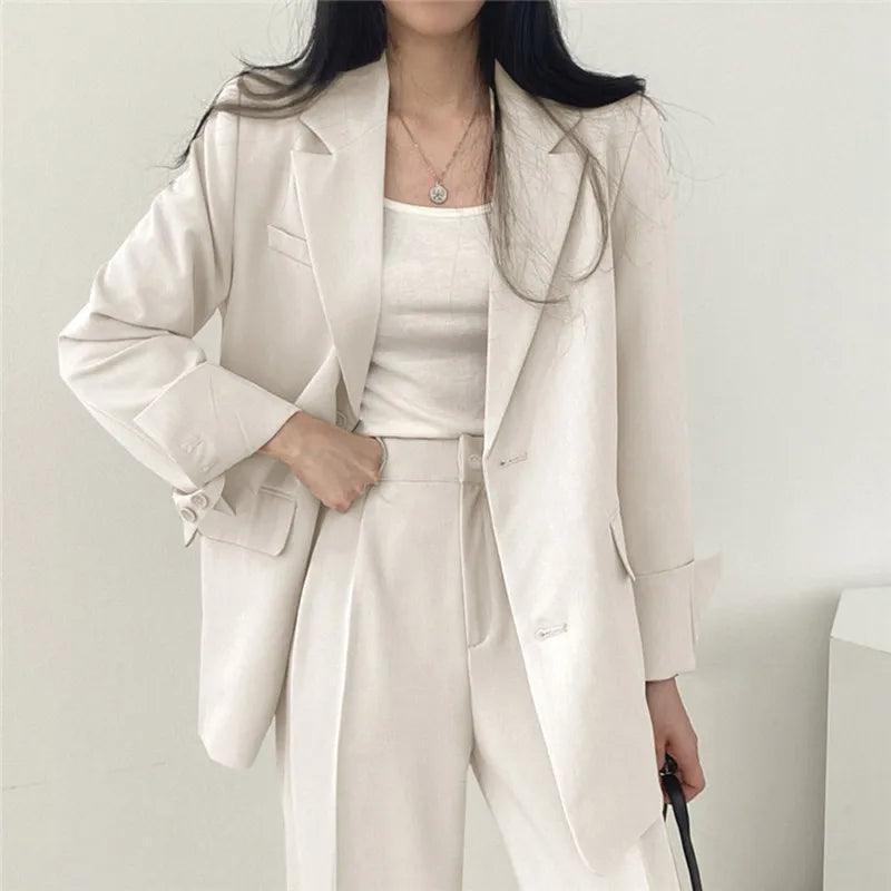 Classic women's tailored suit with an extended-length blazer and coordinated pants for business.