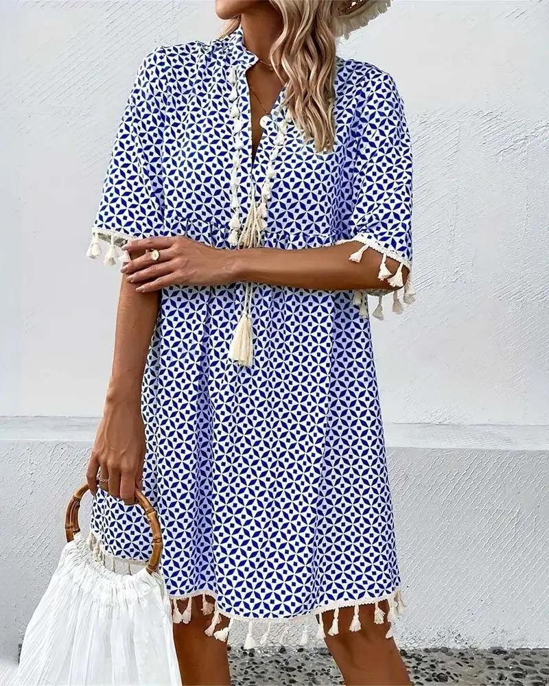 Casual women's short sleeve mini dress with a vibrant print, V-neck, and fashionable tassel trim. Summer style.