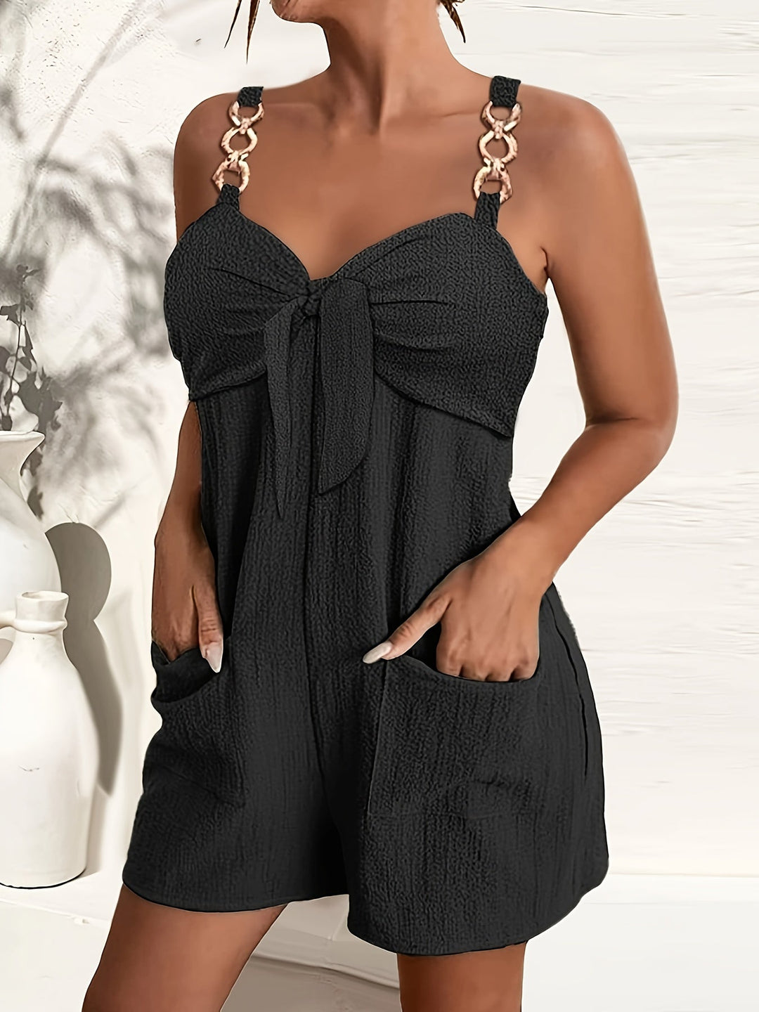 Women's textured short romper with sweetheart neck and stylish chain straps.