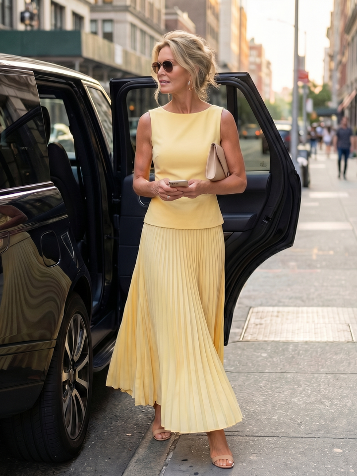 Refined women's structured bodice and pleated maxi skirt two-piece set. Elegant summer party fashion.