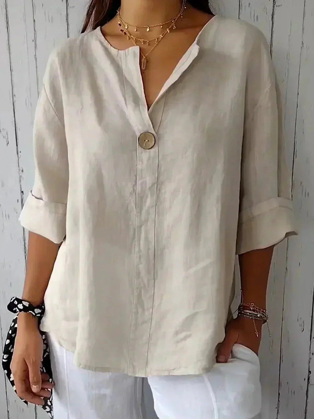 Women's V-neck blouse with roll-tab sleeves, button-down front & relaxed fit for casual or office wear.