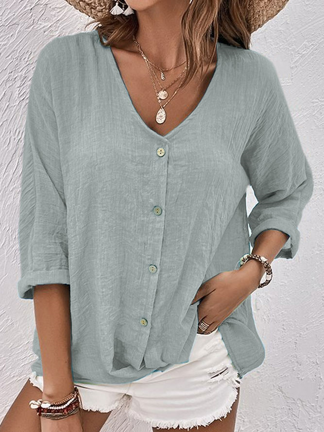 Close-up of a women's V-neck long sleeve button-down shirt, highlighting its design details & soft fabric.