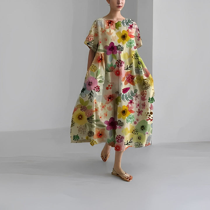 Women's vibrant floral maxi dress in a garden setting, ideal casual summer or vacation fashion.
