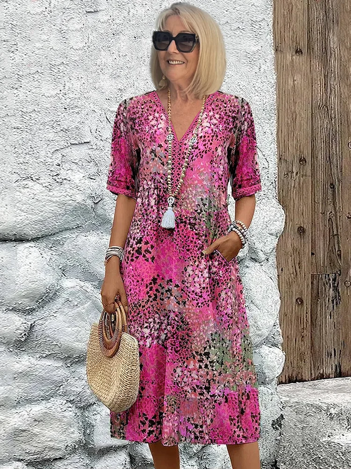 Ocean blue flowy midi dress with practical pockets, vibrant print, ideal for elegant summer events.