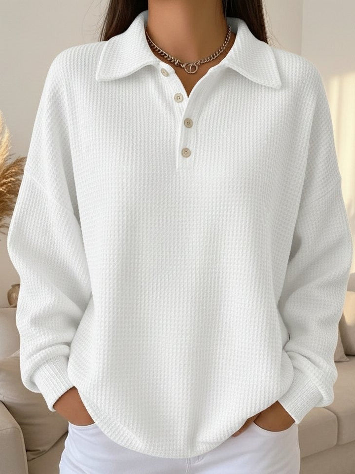 Close-up of women's collared Henley sweater with waffle texture. Long-sleeve pullover for cozy autumn comfort.
