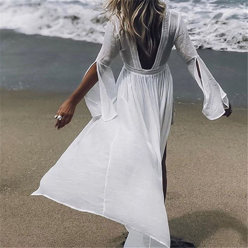Women's white maxi beach dress with elegant open back and flowy flare sleeves. Perfect for resort wear.