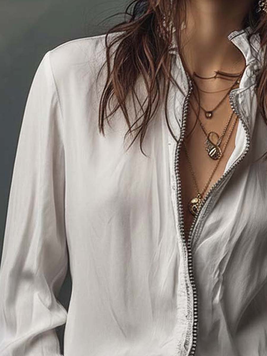 Crisp white women's blouse with a smooth zip-front detail and flowing bell cuffs. Casual elegant style.