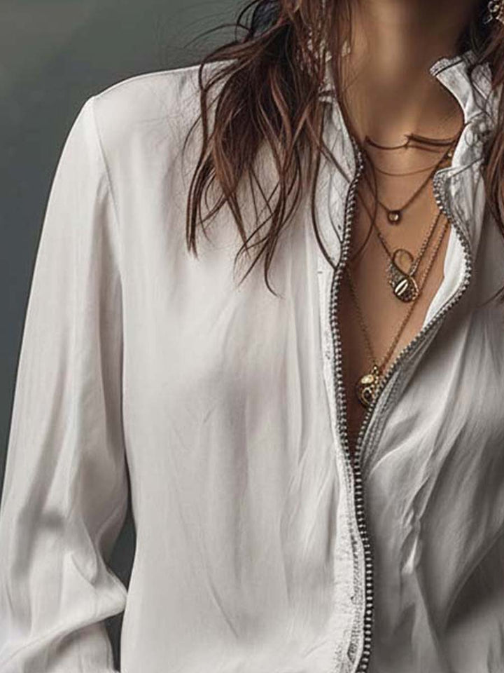 Crisp white women's blouse with a smooth zip-front detail and flowing bell cuffs. Casual elegant style.