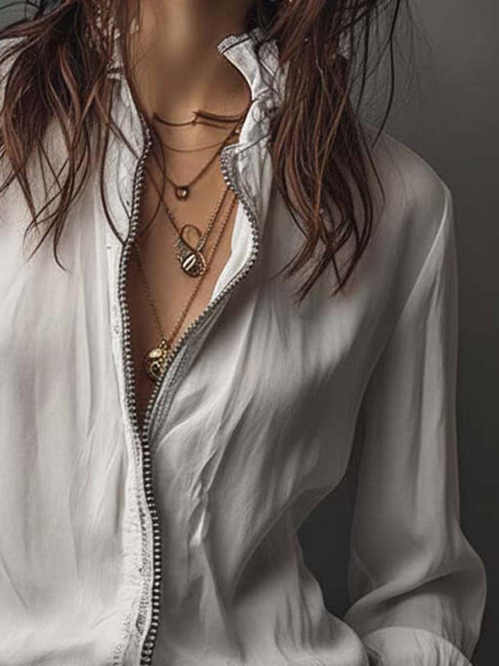 White zip-front women's blouse with graceful bell cuffs, offering a tailored fit and long sleeves. Classic appeal.