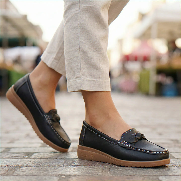 Black slip-on women's loafers, wide fit, arch support, promoting foot health.
