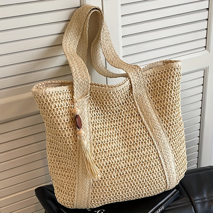 Versatile straw tote bag for women, featuring a beautiful woven texture, fringe, and a tassel detail.
