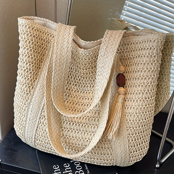 Women's fringe tassel straw tote bag, expertly woven for a durable and fashionable summer look.