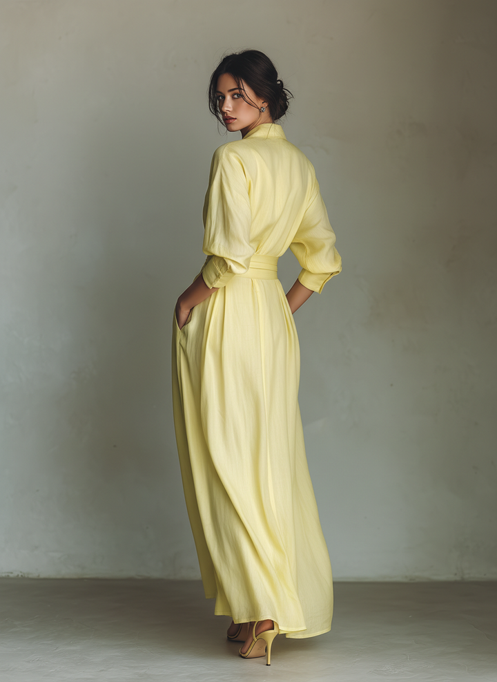 Women's bright yellow maxi shirt dress. Elegant and casual, with a flowy design, long sleeves, and V-neck for summer.