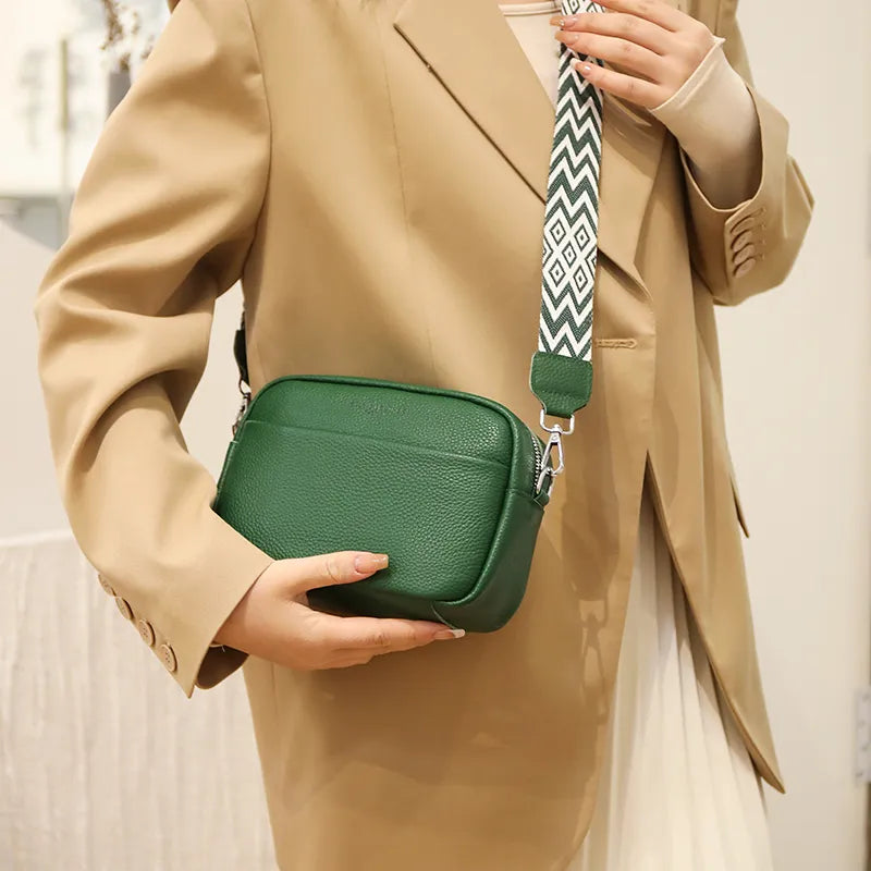 "Women's boxy camera bag with detachable chevron strap, pebbled texture, rectangular shape, and secure zip closure."