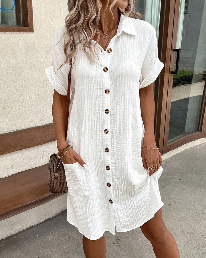 "Women's white cotton polo shirt dress with pockets, featuring a relaxed fit, polo collar, and wrinkle-resistant fabric."